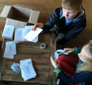 Jared en Faye plakken postzegels op de groeikaartjes